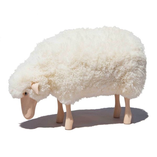 Kleines Schaf grasend mit weißem Schaffell mit zusätzlicher Polsterung